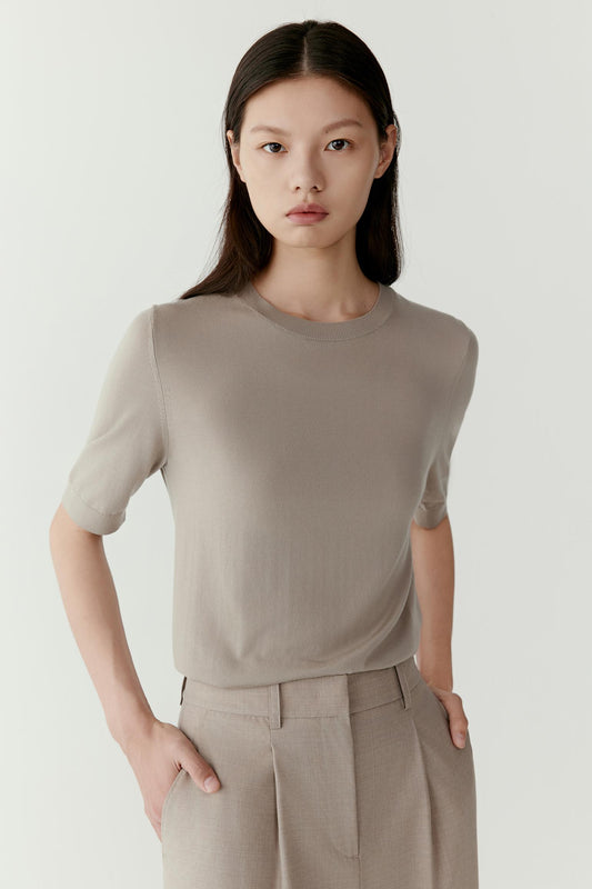 Three-quarter view emphasizing the fluid structure of the knit fabric and the clean minimal silhouette of the tee.