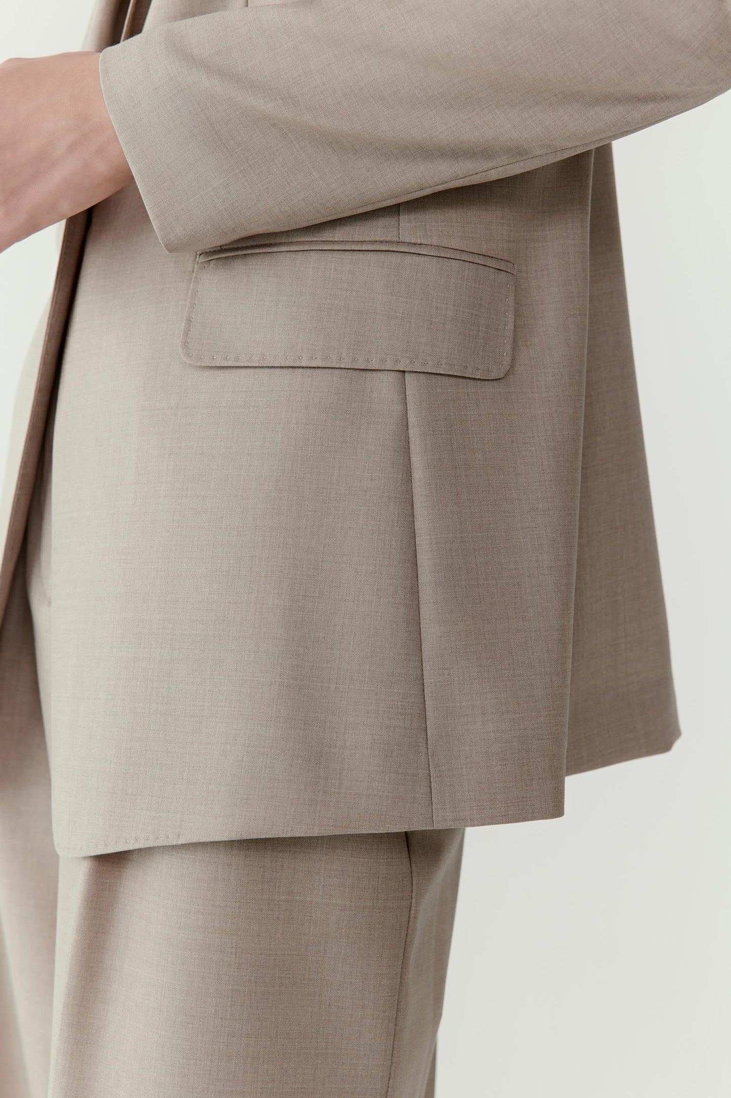 The final image focuses on the blazer’s pocket and refined tailoring details.