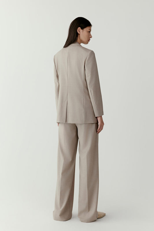 The same outfit is viewed from the side, showing the blazer’s straight cut and soft drape.