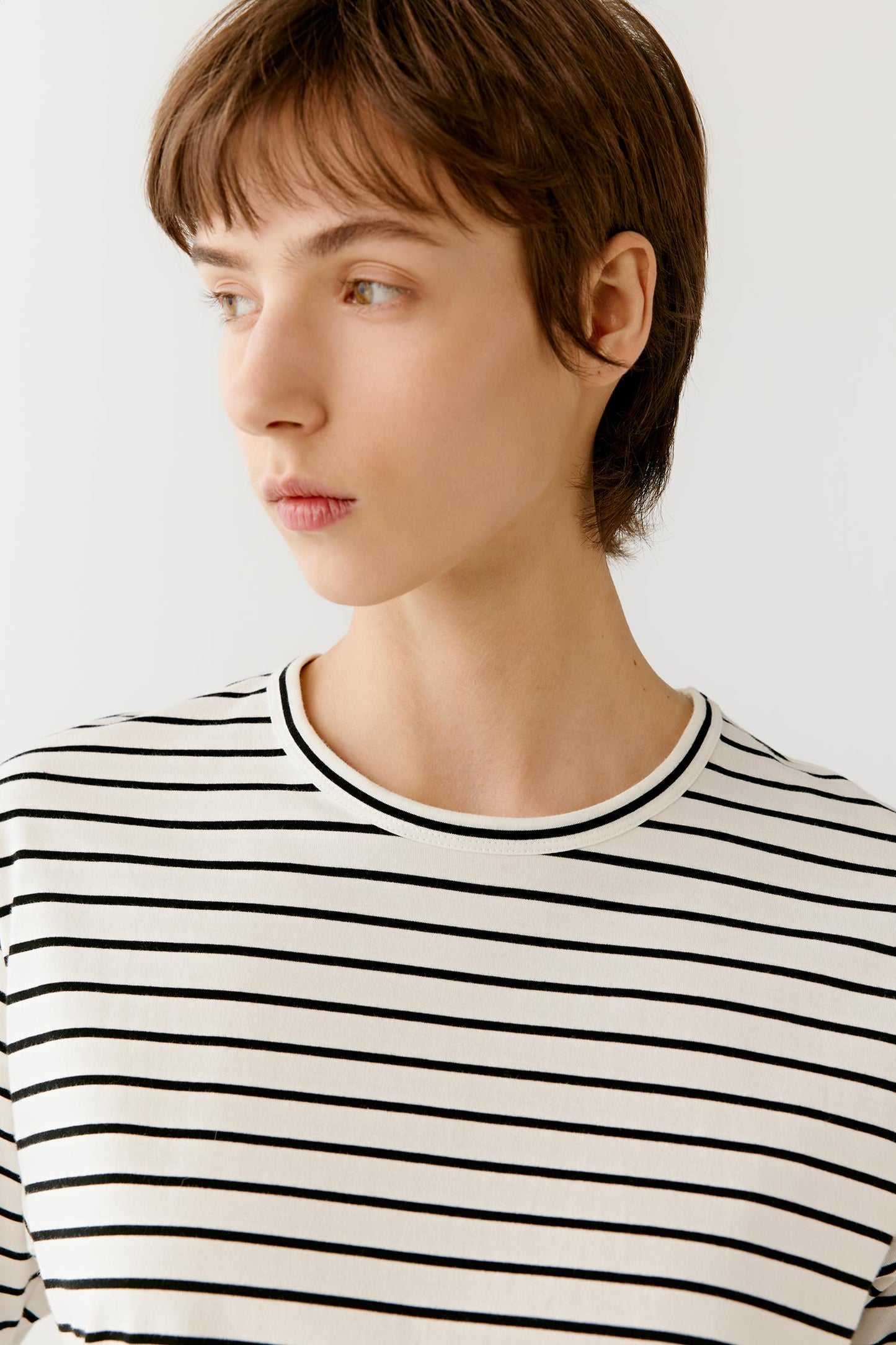 Close-up of the neckline and chest area highlighting the clean finishing, lightweight cotton jersey construction and precise stripe alignment. The image emphasizes the soft hand, smooth texture and understated character of the fabric.