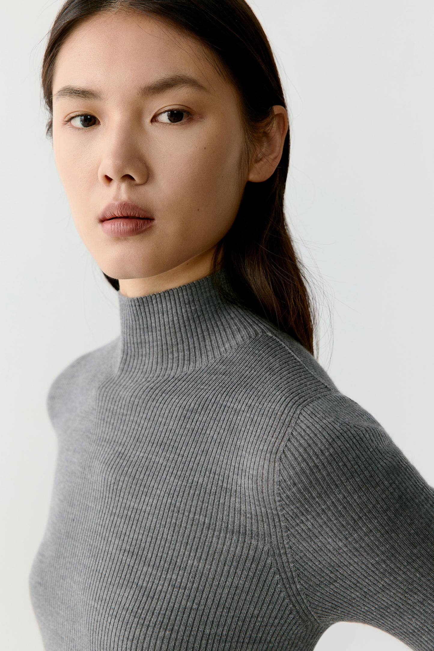 The final image shows the profile of the neckline and shoulder, emphasizing the clean construction and fluid stretch of the fabric.