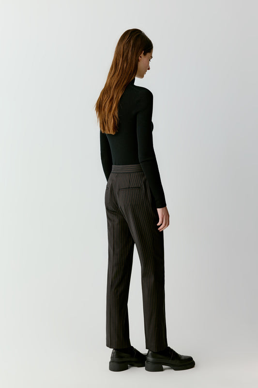 The side view reveals the slim fit and mock neck that defines the silhouette.