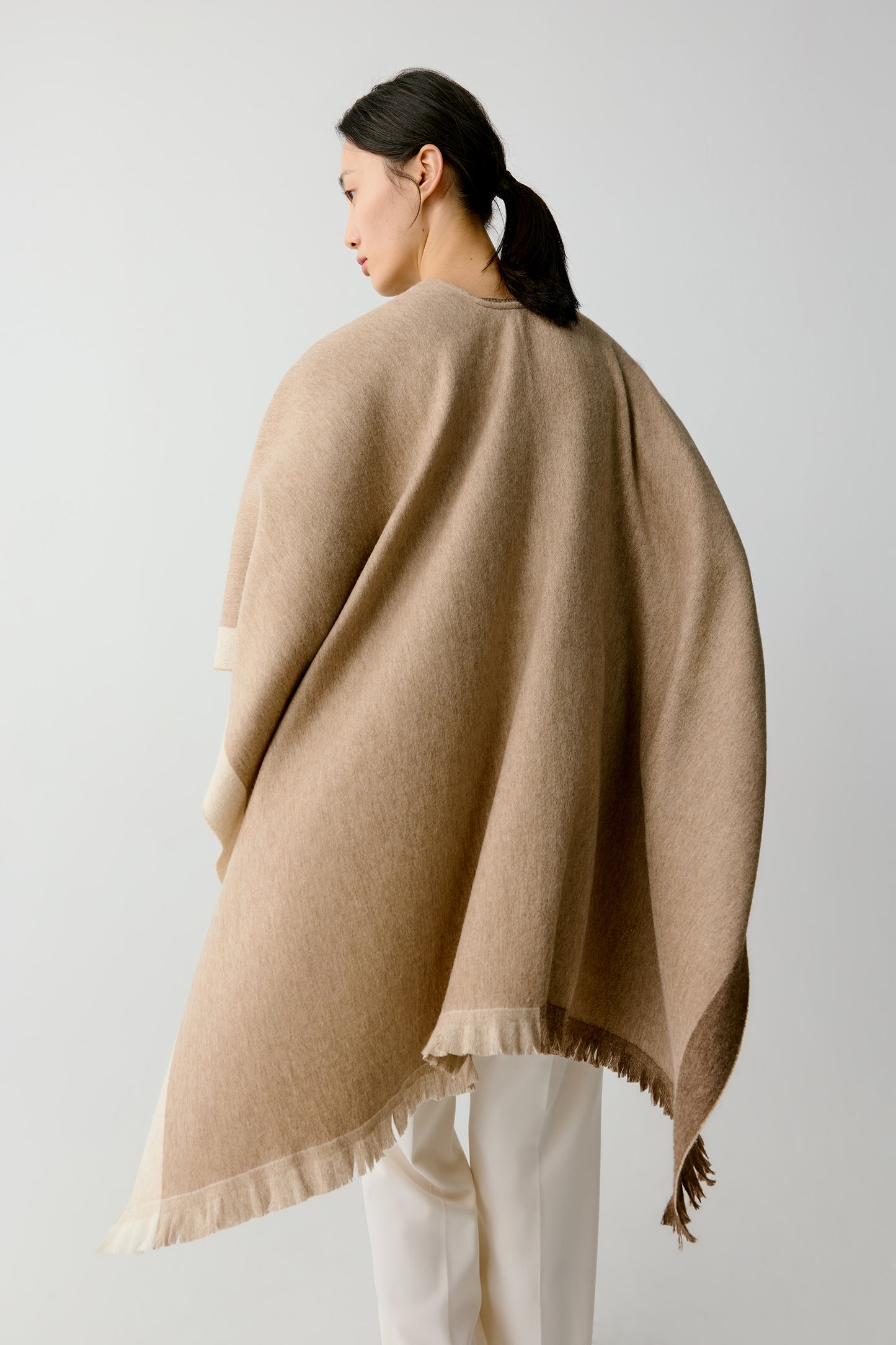 Rear view highlighting the smooth fall and light movement of the shawl.