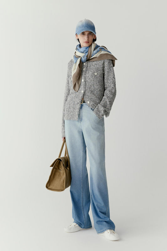 Full-length view showing the scarf styled around the neck with the ends falling loosely over a textured knit sweater. The cashmere and silk blend creates a soft surface and fluid movement.