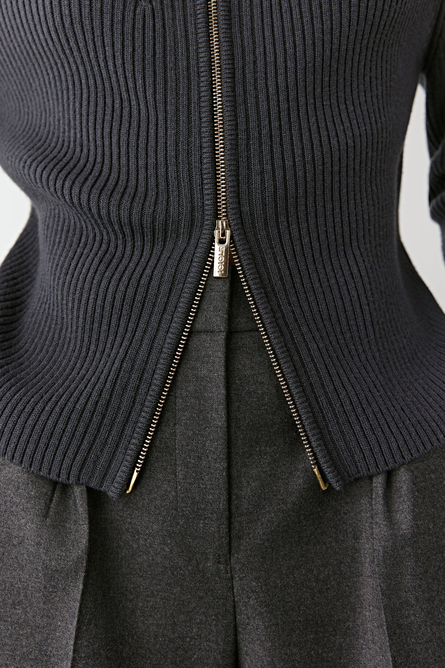 Close-up of the zip and ribbed fabric texture, showing the fine knitting and smooth finishing.