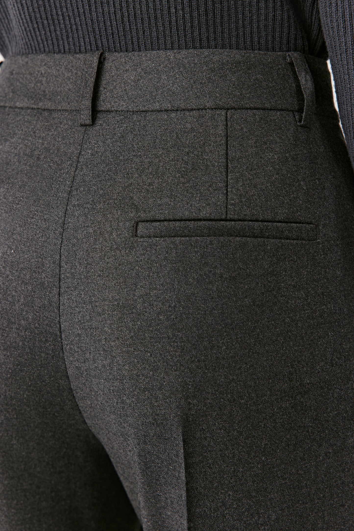 Close-up of the waistband and pleats, showing the flannel texture and refined tailoring.