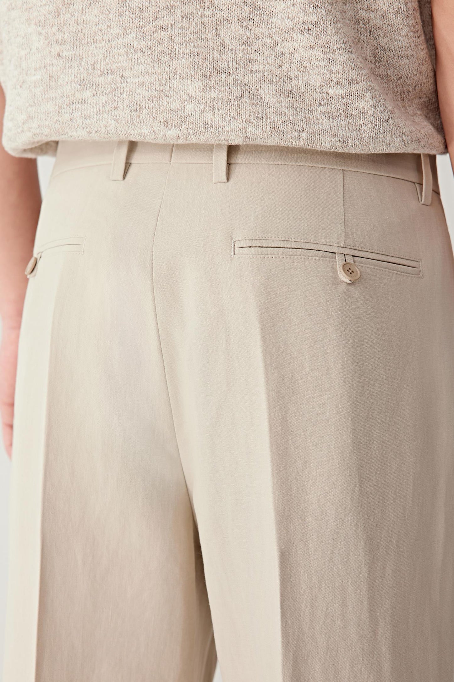 Close-up of the waistband and front construction, highlighting the clean finishing, seam lines and the dry, lightly crisp hand of the fabric, with subtle variations in the beige shade enhancing the natural character of the material