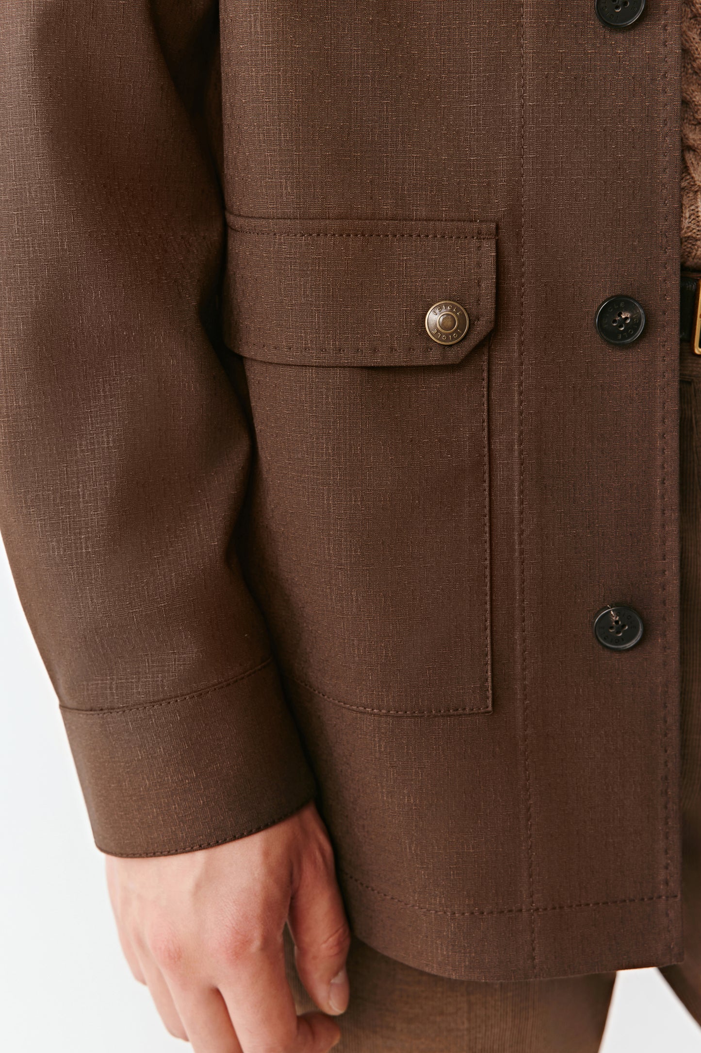 Close-up highlighting the patch pocket and slit cuff details.