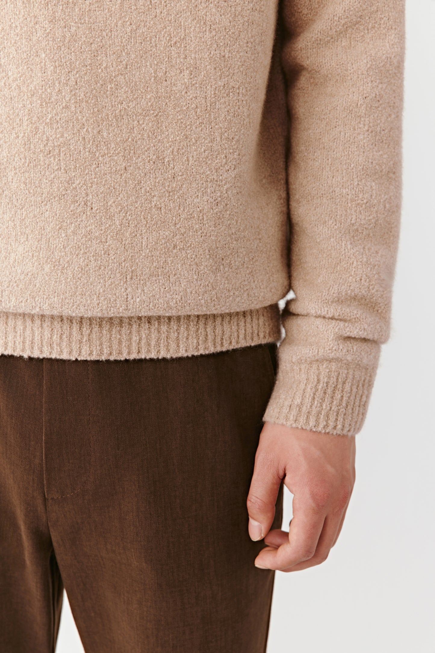 Detail of the sleeve and hem showing the texture and finishing quality.