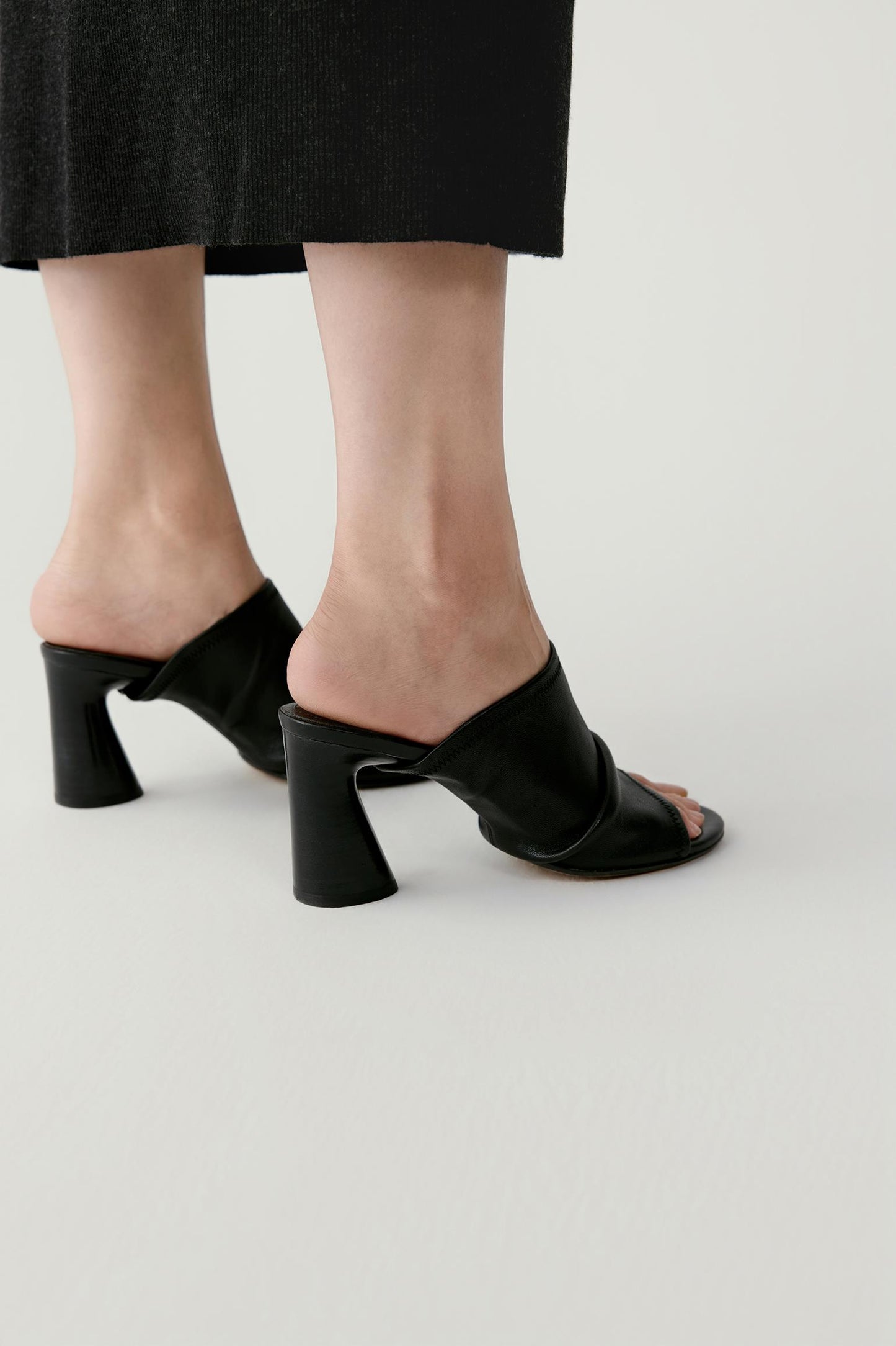 Three-quarter view emphasizing the gathered leather detail and the balanced structure of the sandal.