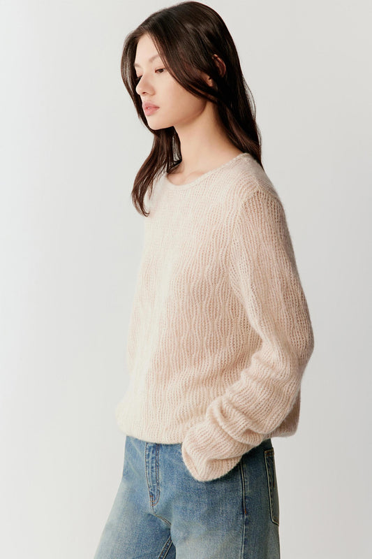 Three-quarter view highlighting the relaxed shape of the sweater and the soft drape of the knit fabric along the body.