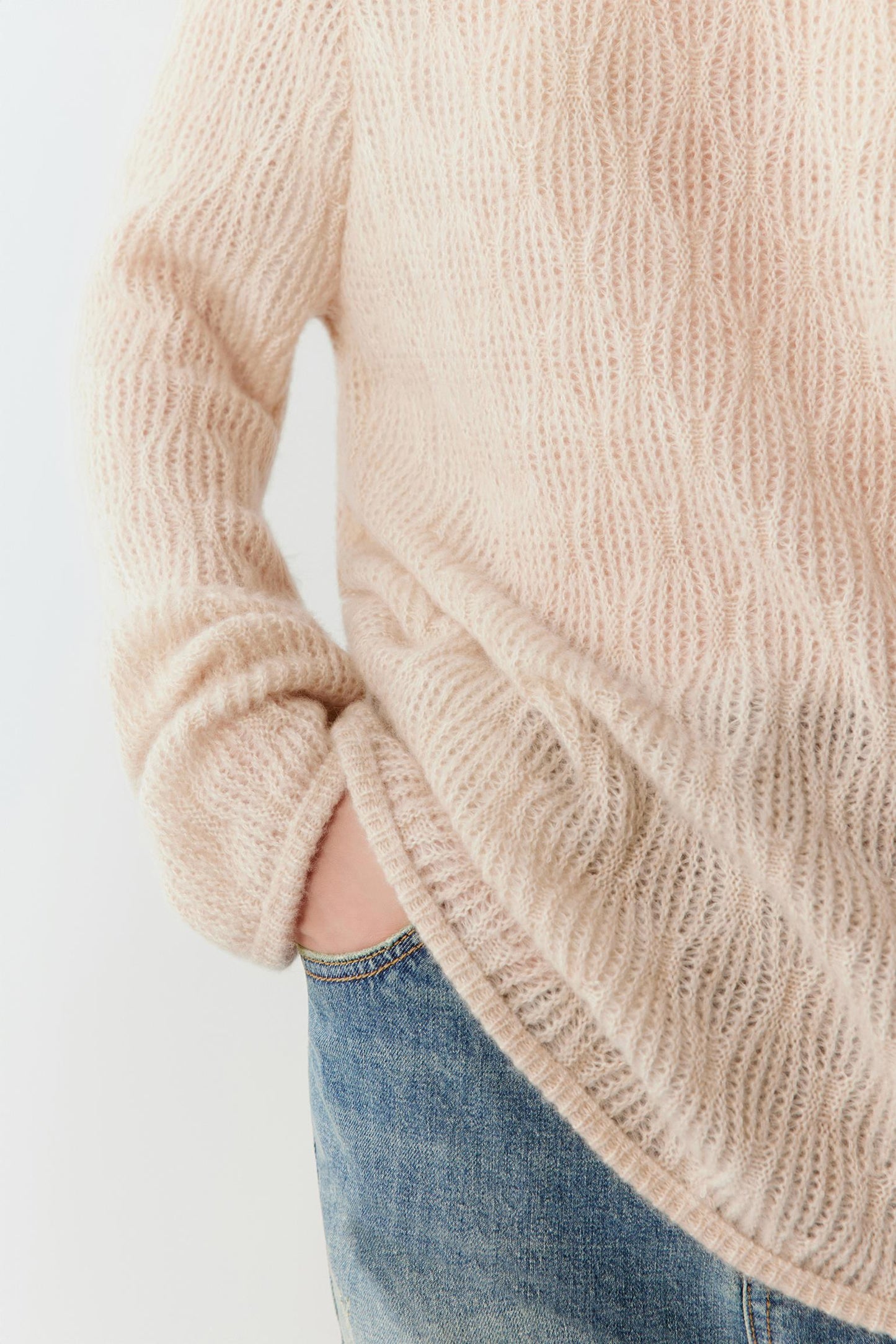 Detail of the sleeve and hem finish showing the refined ribbed edges.