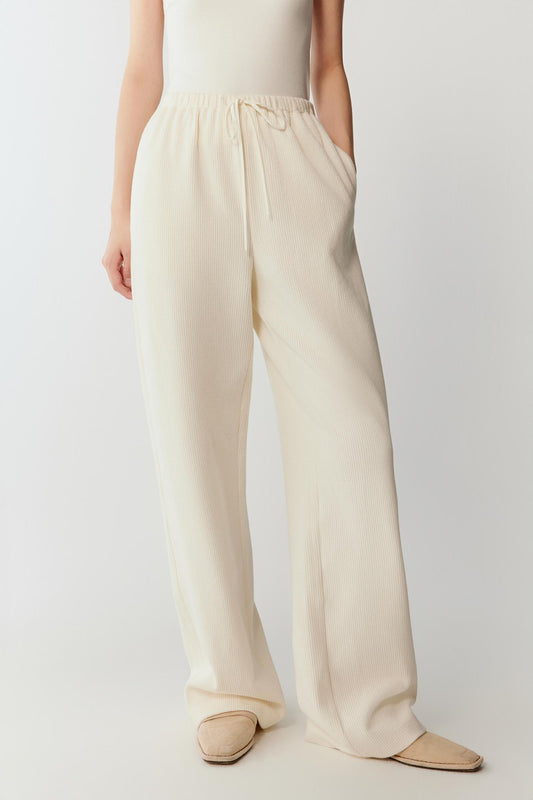 Three-quarter view highlighting the fluid drape of the ribbed jersey fabric and the relaxed proportions of the silhouette.