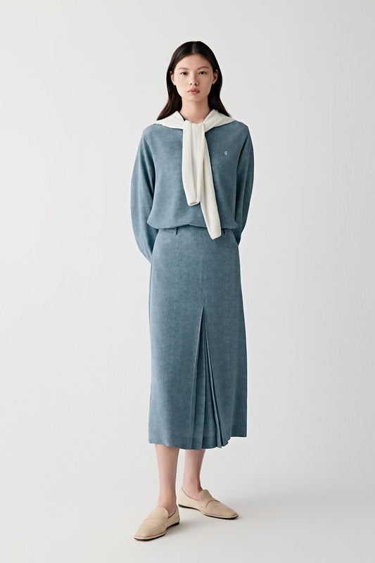 Full-length front view showing the blouse styled with a matching skirt, emphasizing the relaxed fit, fluid fall and tonal indigo blue shade with subtle depth and a softly matte surface