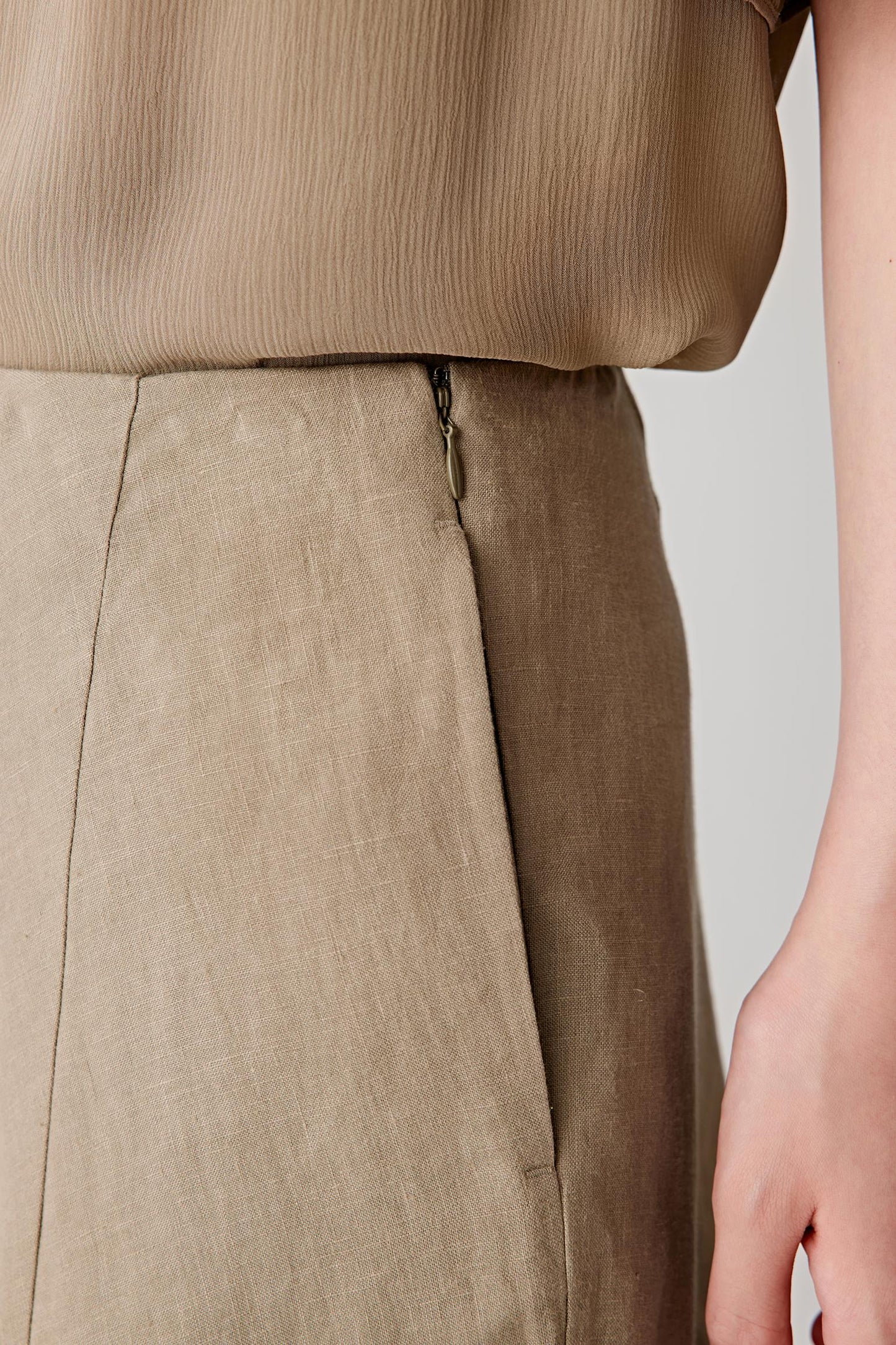 Close-up of the side pocket and fabric surface, showing the visible weave, natural irregular texture and dry hand characteristic of linen. The image highlights the subtle tonal depth and lightweight structure of the material.
