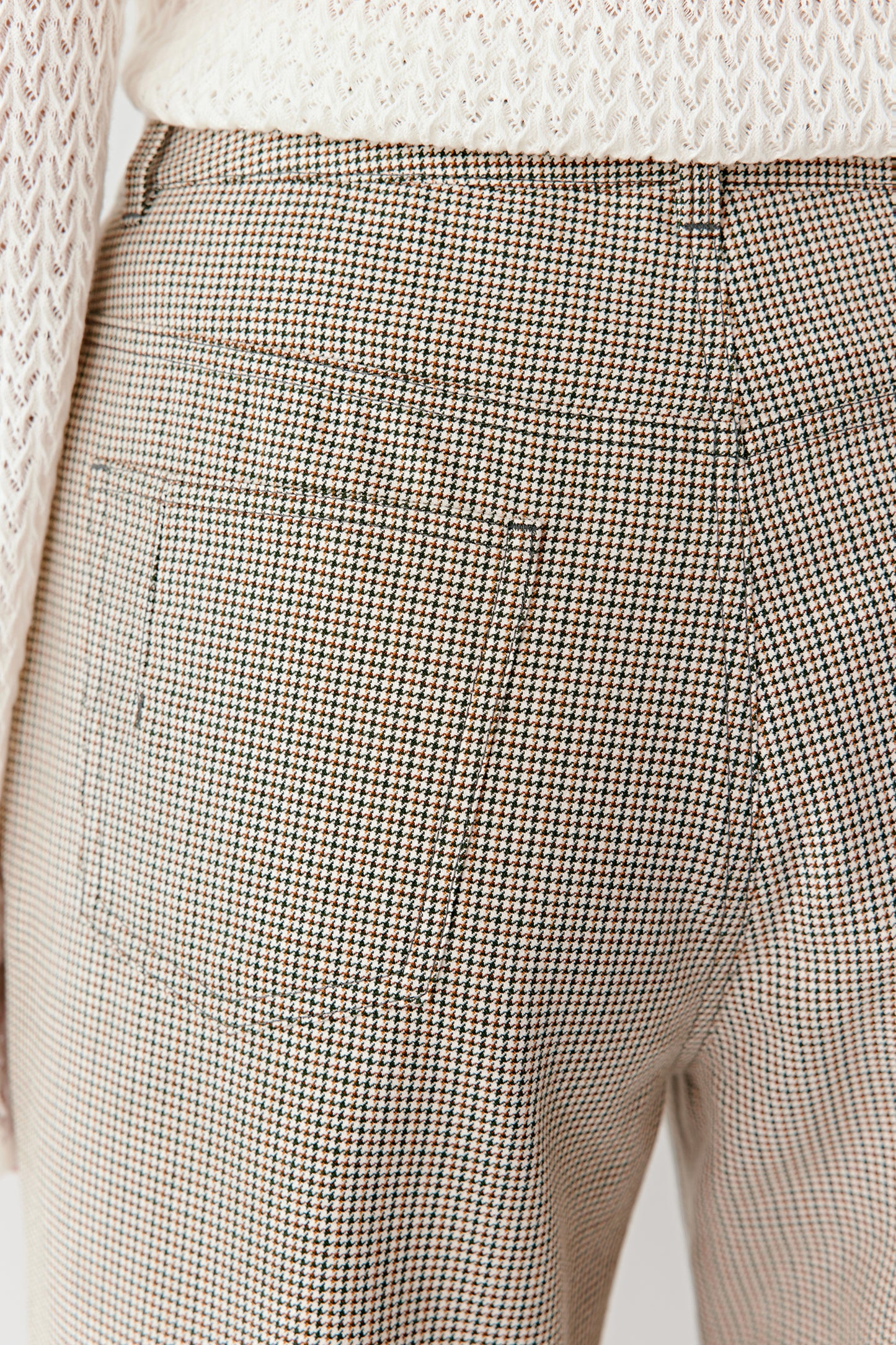 A close-up reveals the cotton and wool weave, showing the green, white and orange threads that create the pattern.