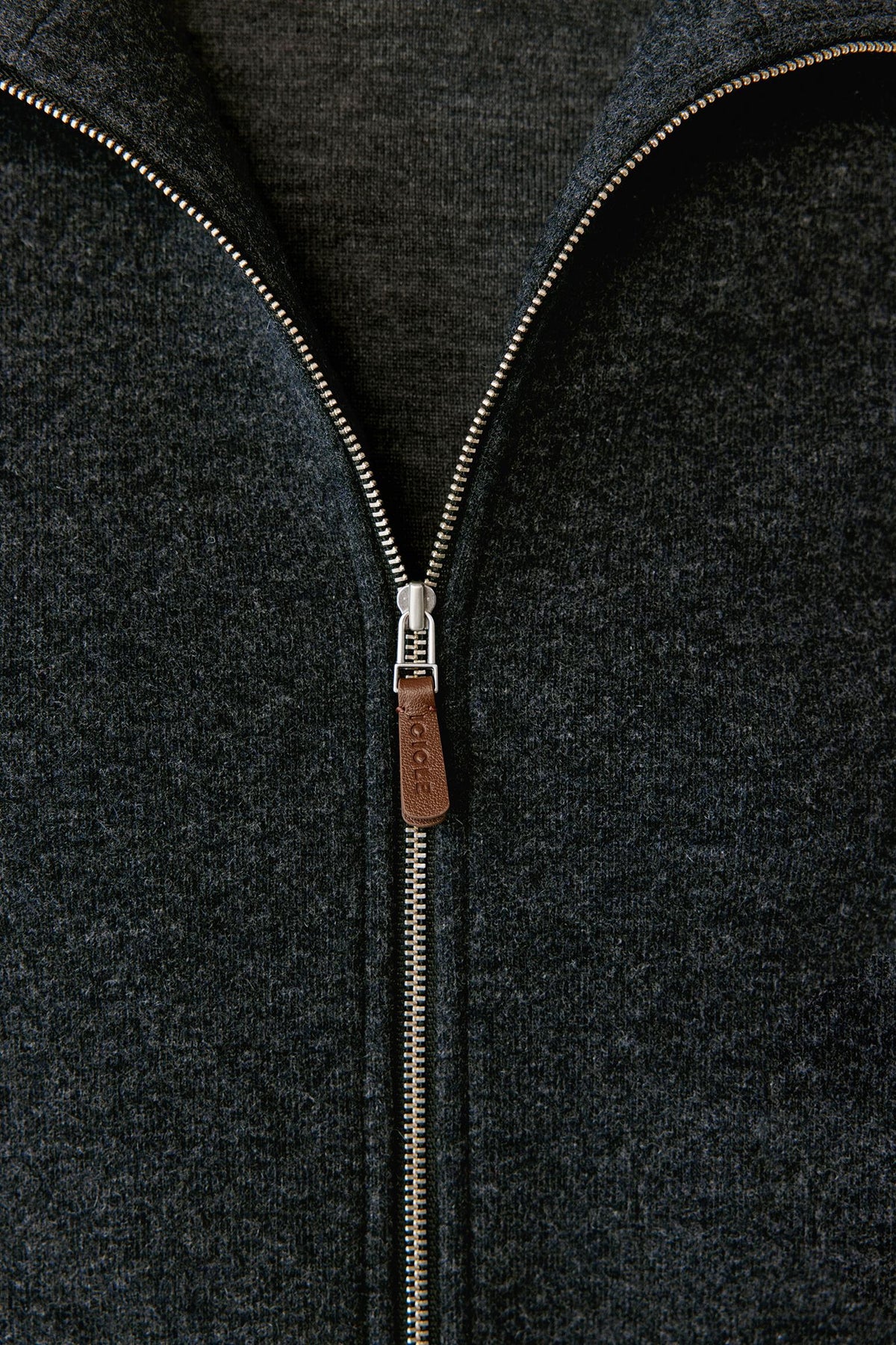 Close-up highlighting the front zip fastening and textured grey melange jersey surface.