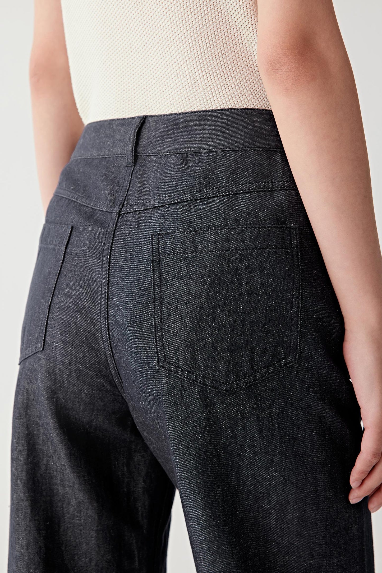 Close-up of the back pocket and seat area, showing pocket placement, seam lines and the grain of the twill fabric, emphasizing its density, matte finish and natural texture