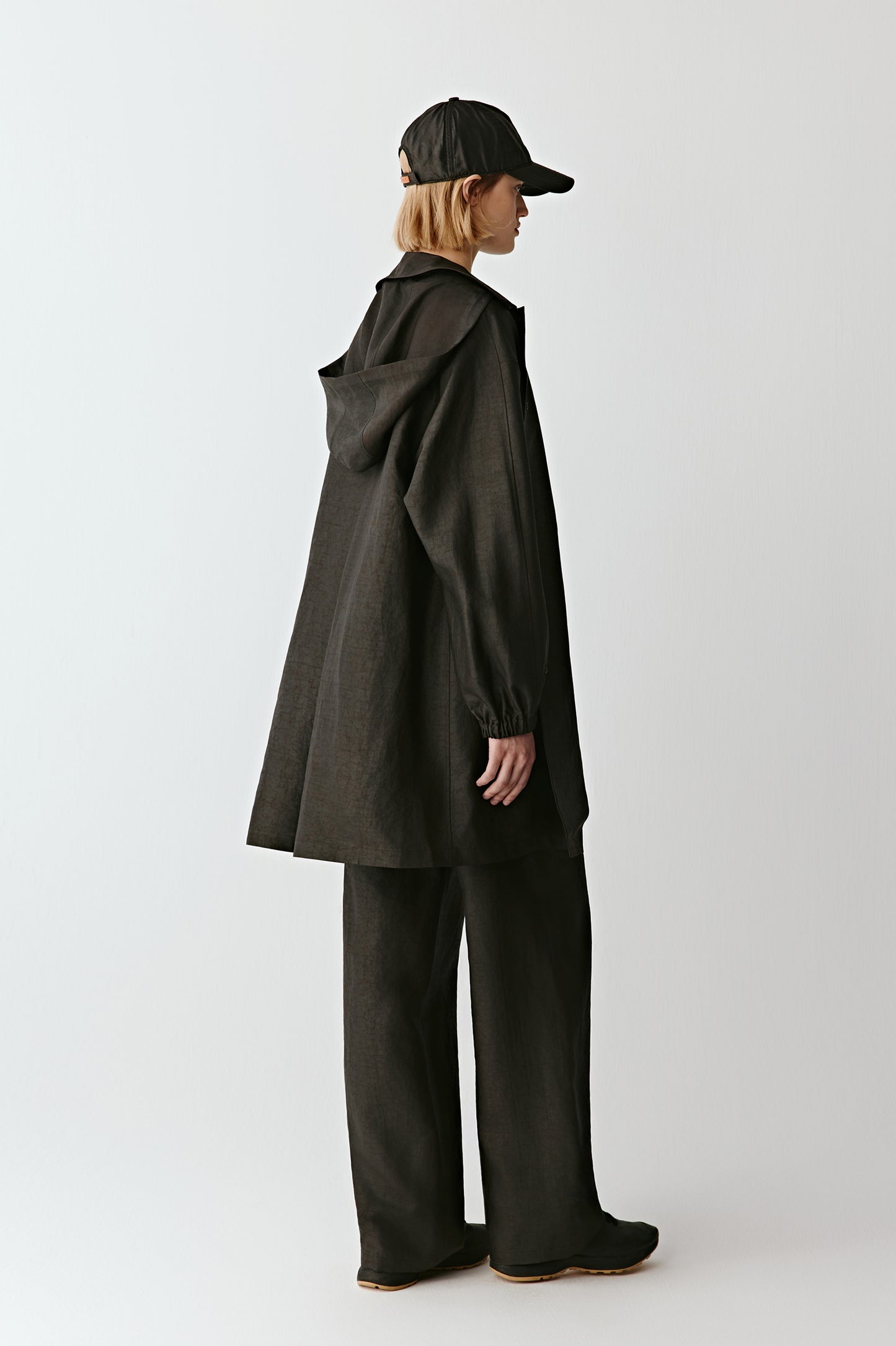 Side view showing the hood and straight cut of the coat.