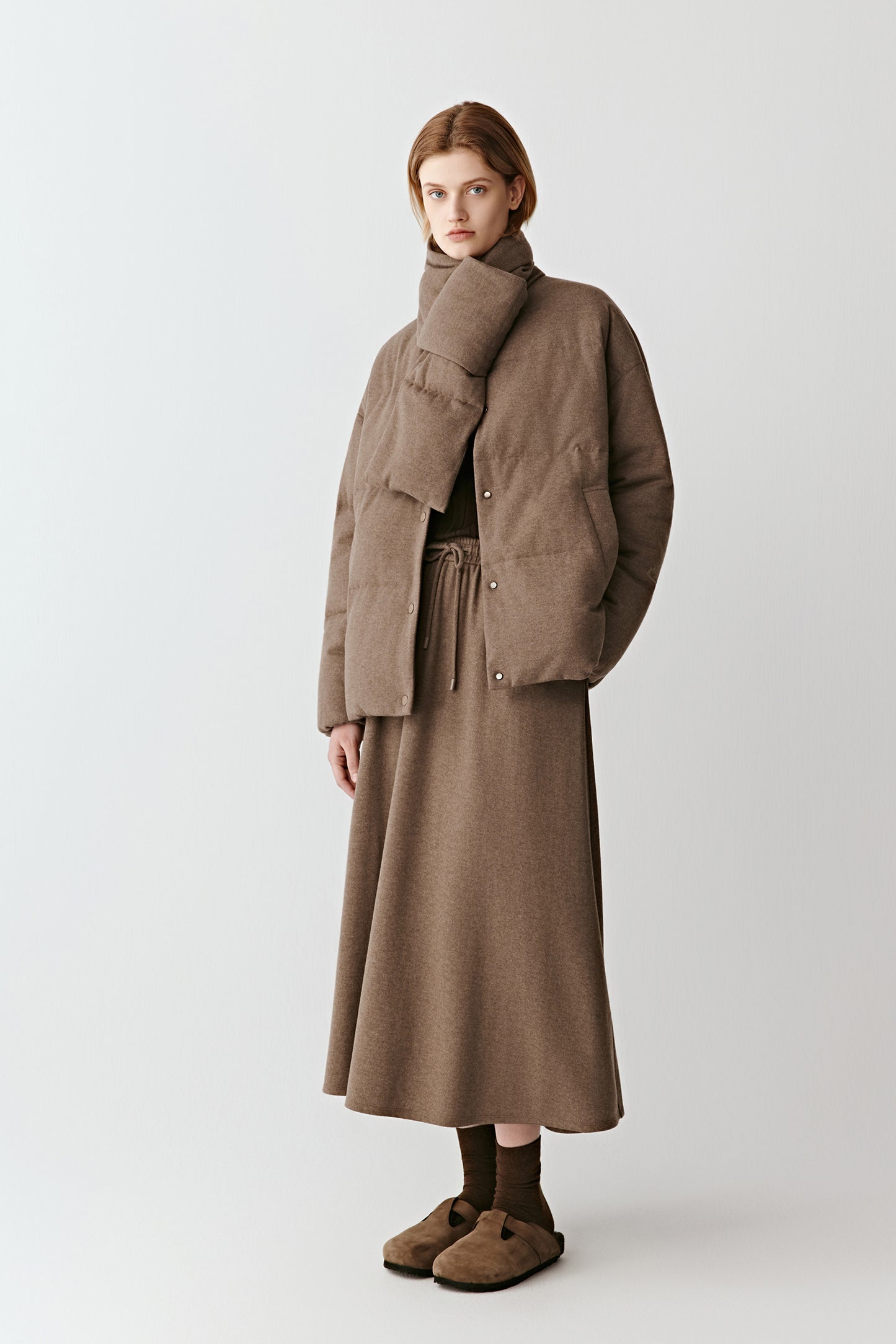 Side view showing the entire look with the brown wool coat and skirt in the same shades.