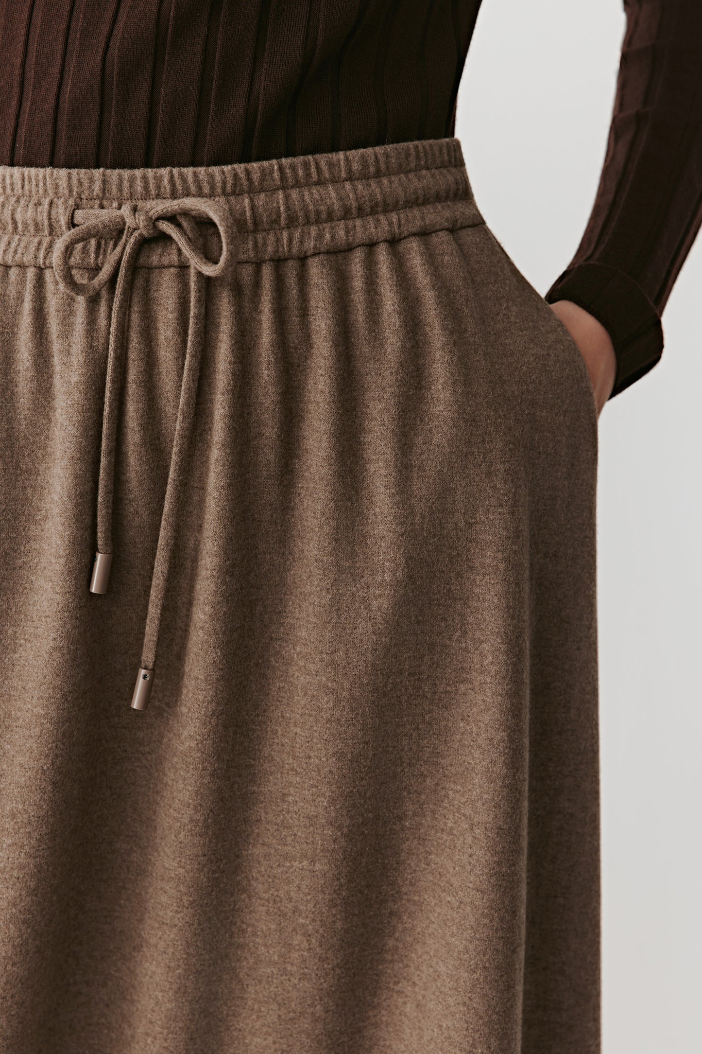 Side detail capturing the structured waistband and discreet seam lines.