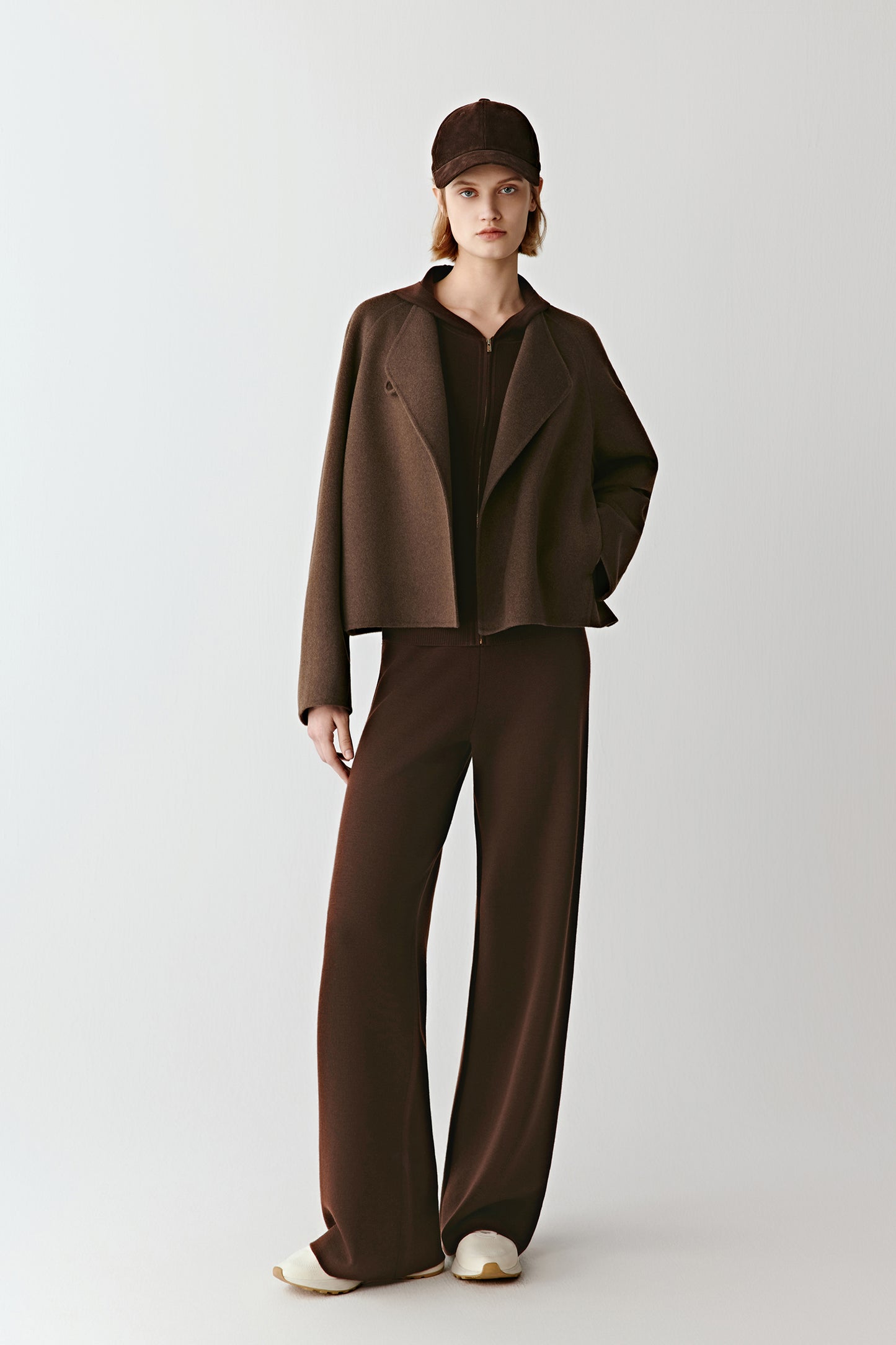 Model wearing the undyed brown yakwool coat with matching trousers, showing its enveloping shape and natural drape.