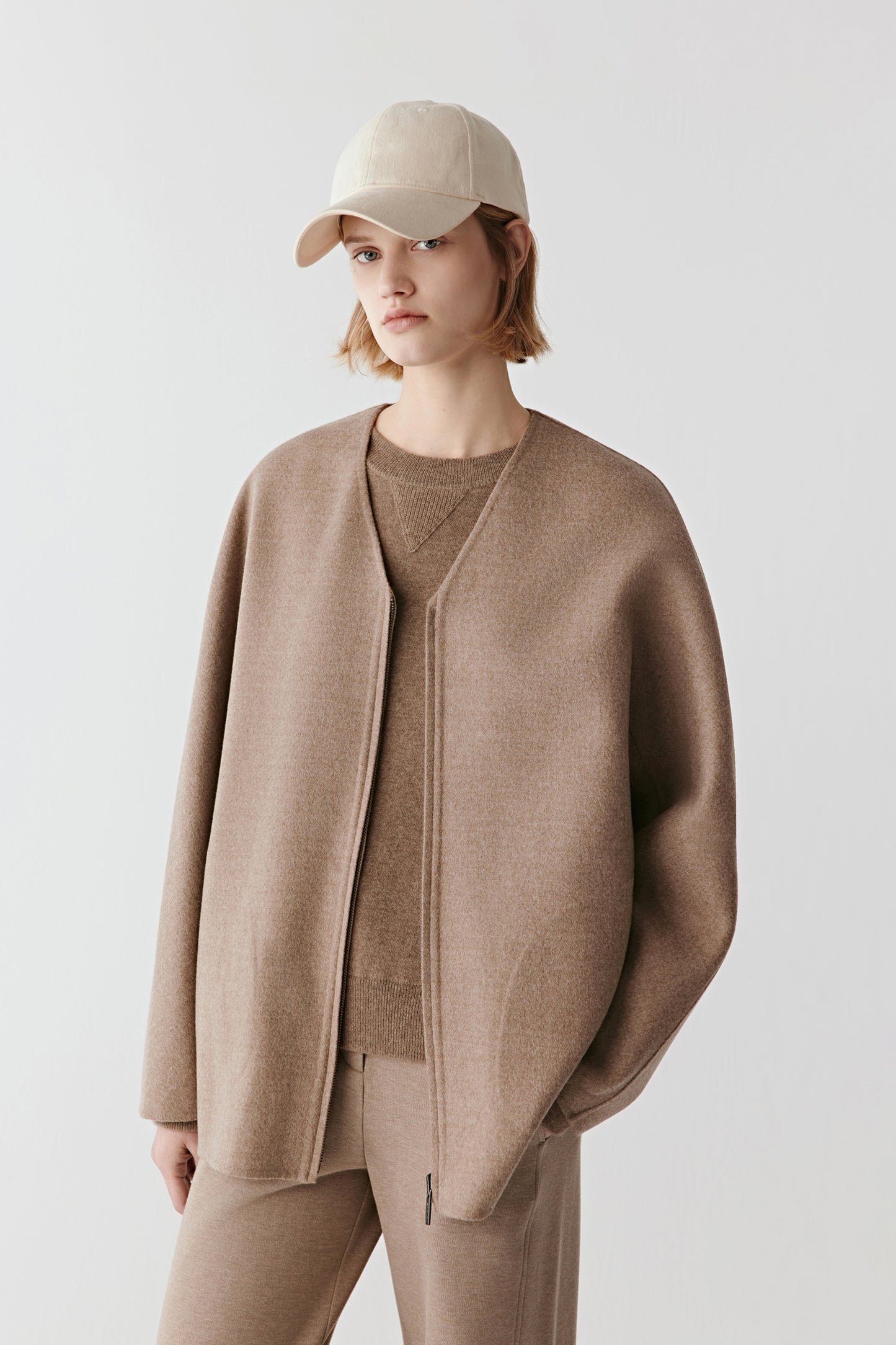 Three-quarter side view showing the loose silhouette and natural movement of the double-faced fabric.