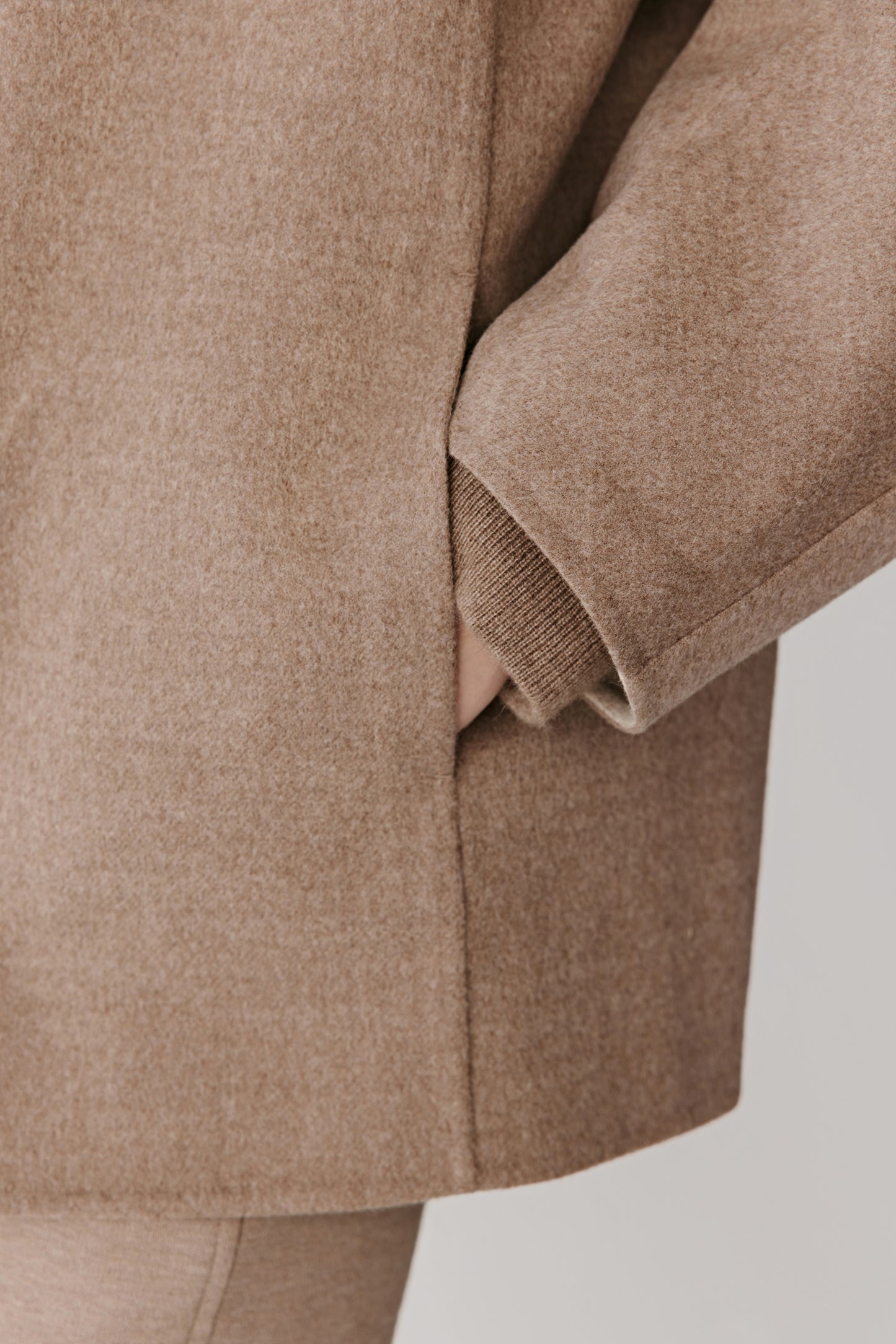 Close-up of the sleeve and side pocket revealing the fine lightly brushed wool texture.