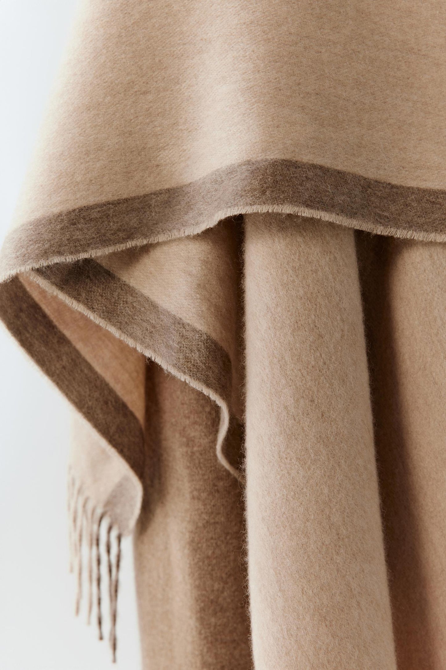 Close-up of the fringed hem revealing the fine weave and plush surface.