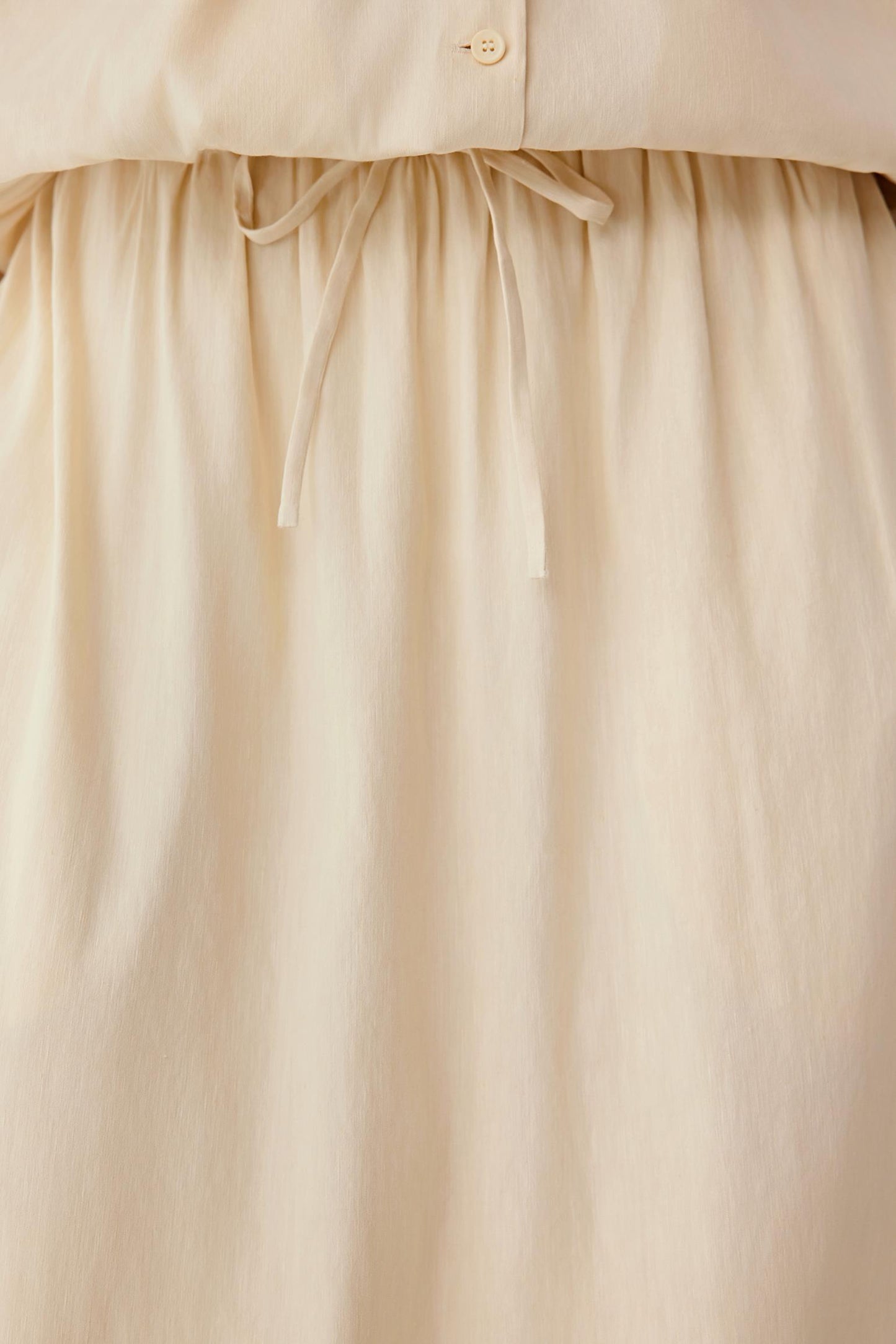 Close-up of the waistband area, showing the elasticated construction, adjustable tie detail and gathered fabric, highlighting stitching and the natural texture of the material