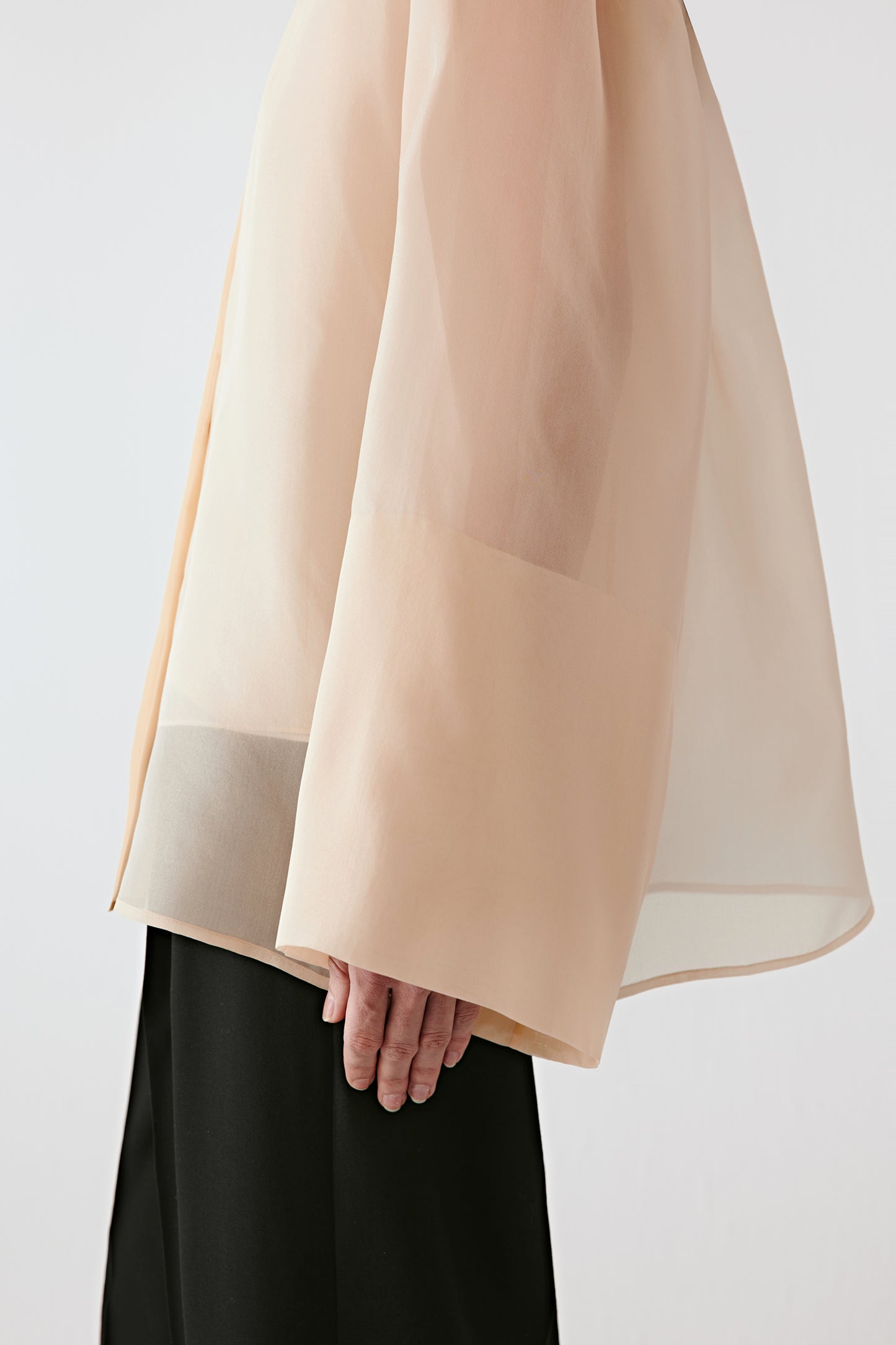 Close-up of the sleeve showing its fluid shape and wide cuff detail.