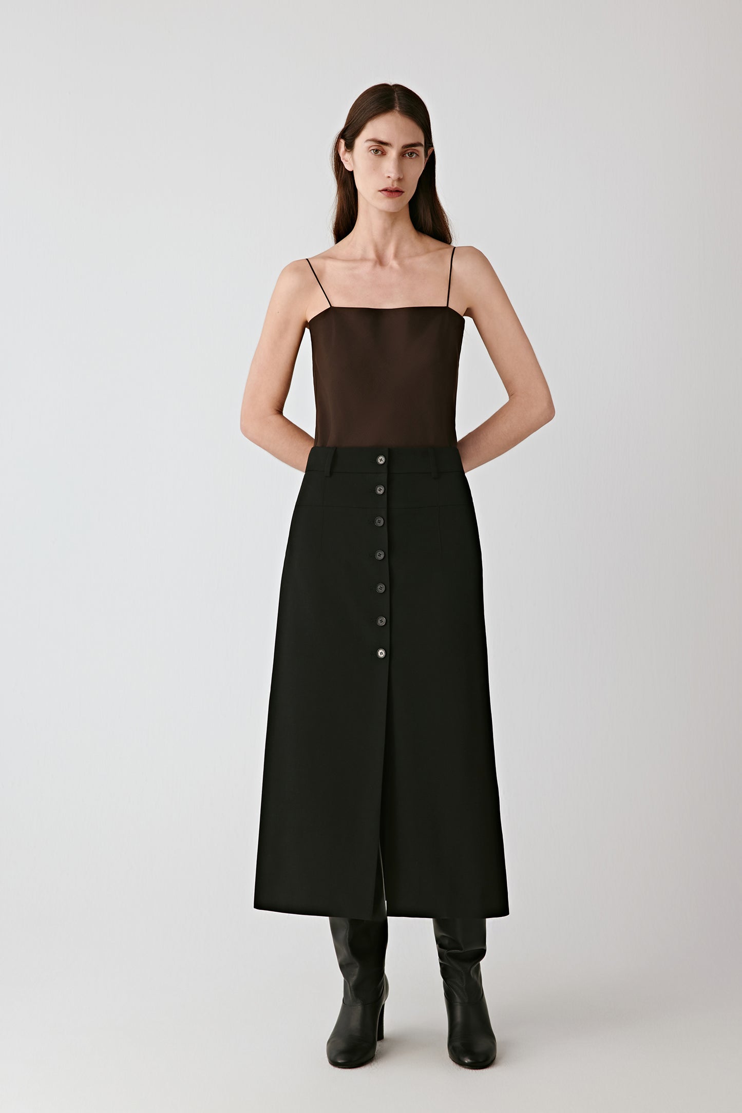 Full-length view capturing the top’s fluid fall over black trousers, highlighting the lightness and subtle sheen of the organza.