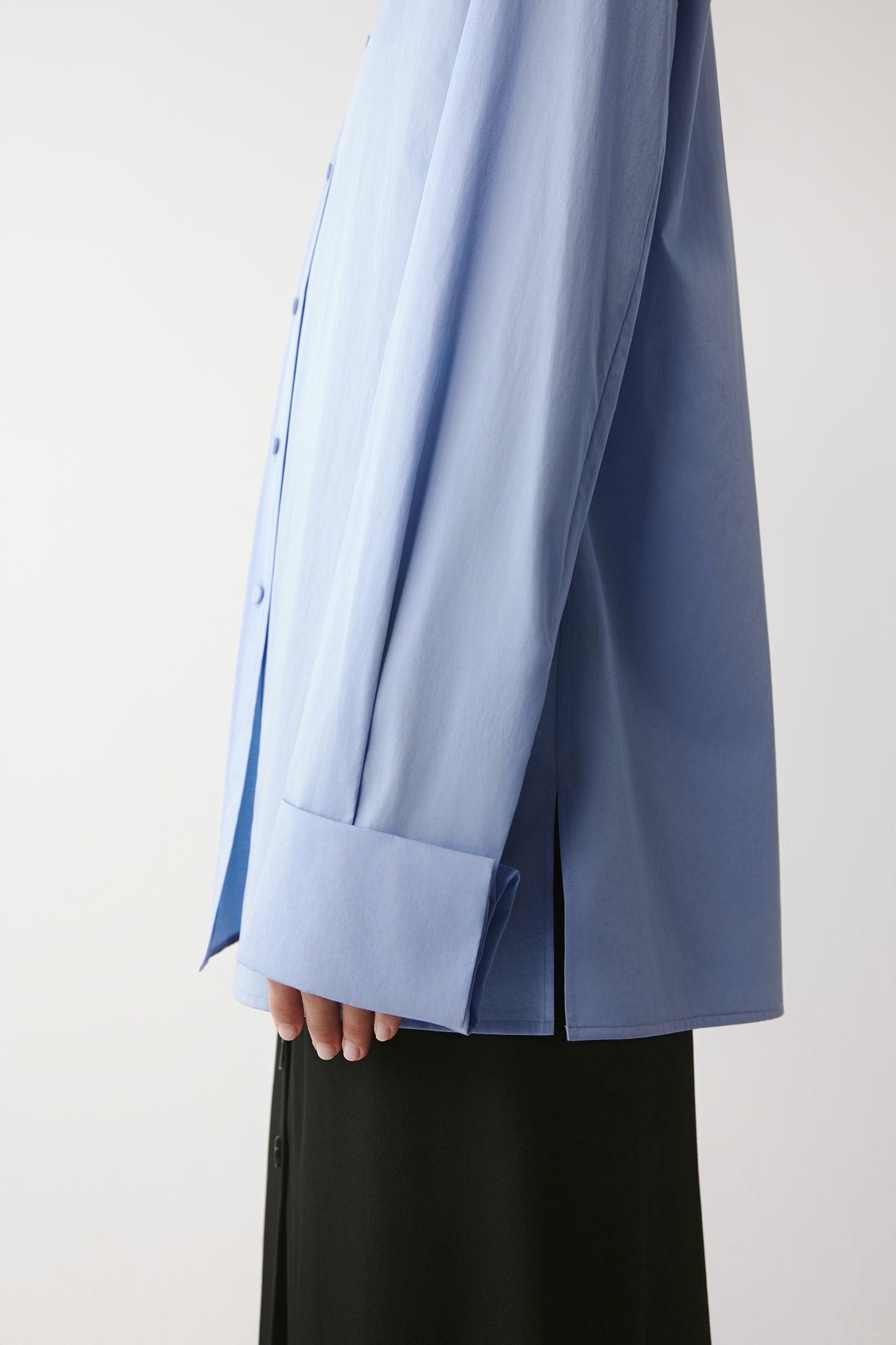 Detail of the cuff and sleeve showing the natural sheen and soft reflection of the cotton satin.