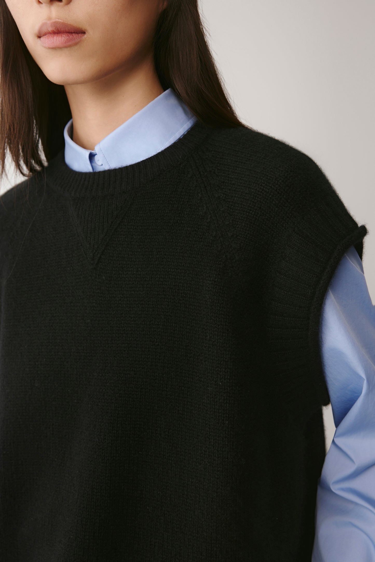 Zoom on the shoulder and armhole detailing emphasizing the precision of the finishing and the vest’s supple texture.