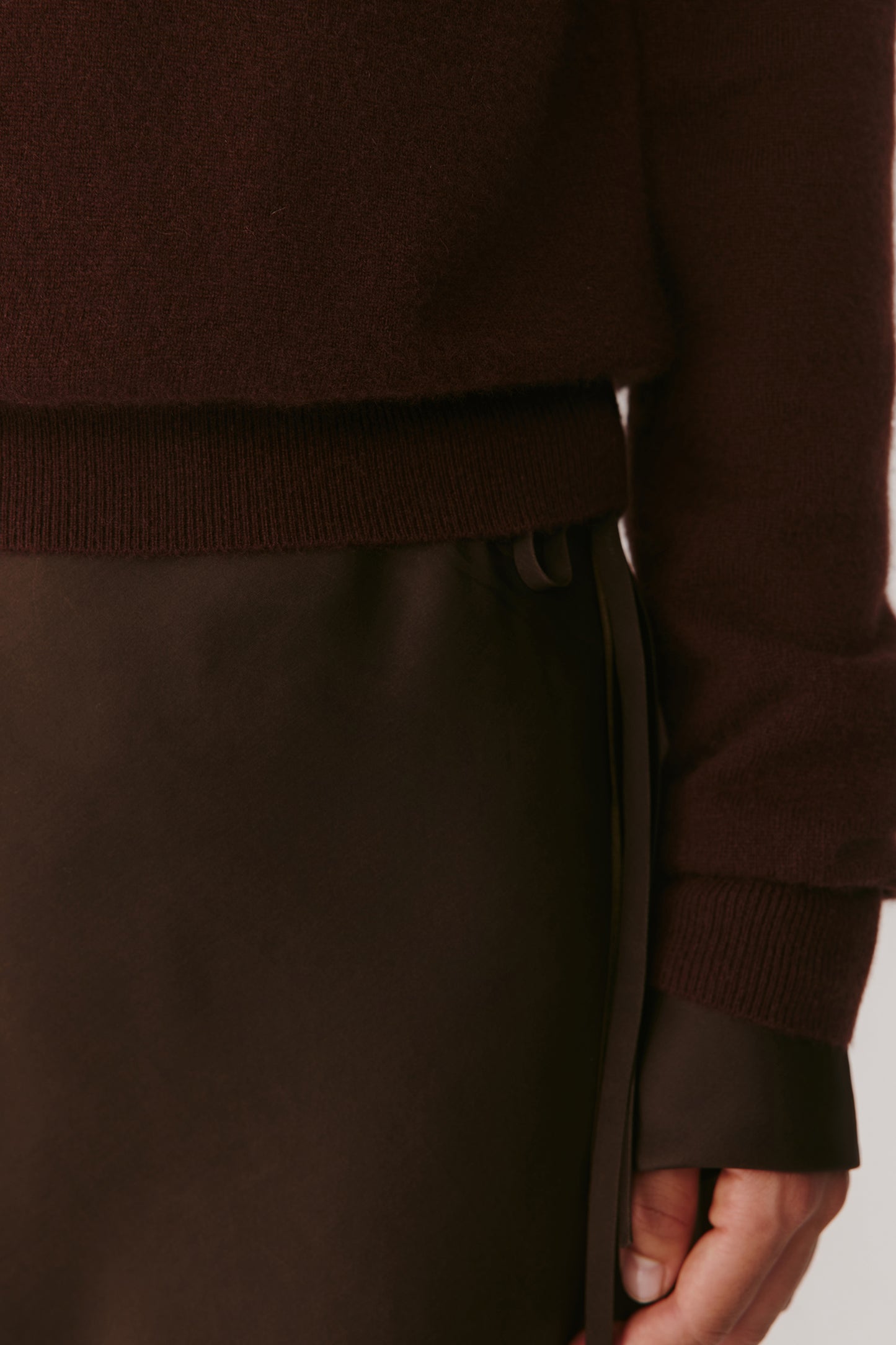 Detail of the lower hem and sleeve cuff illustrating the uniform ribbed edges and softness of the material.