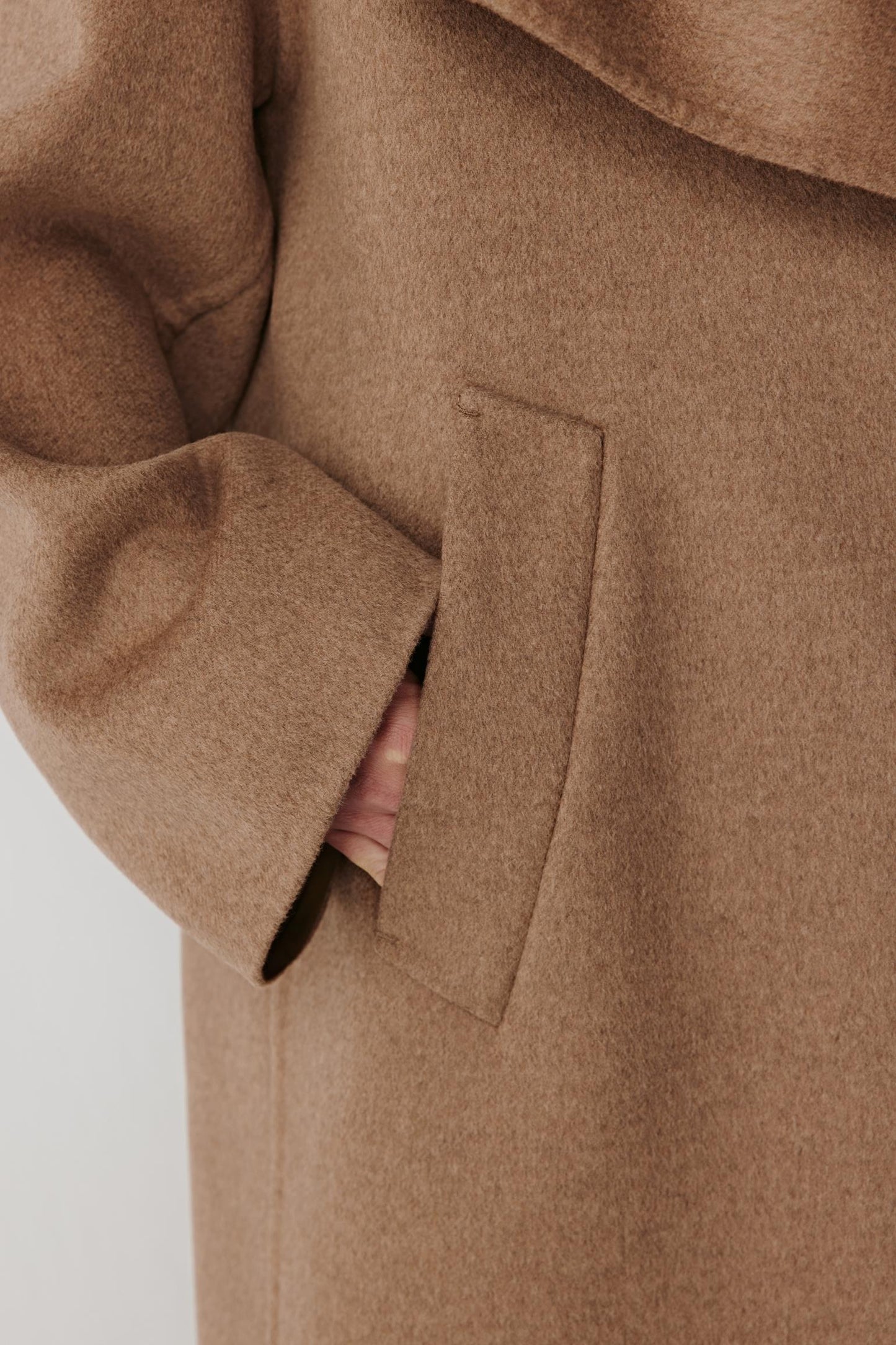 Detail of the pocket and sleeve hem emphasizing the smooth structure and high-quality finish.