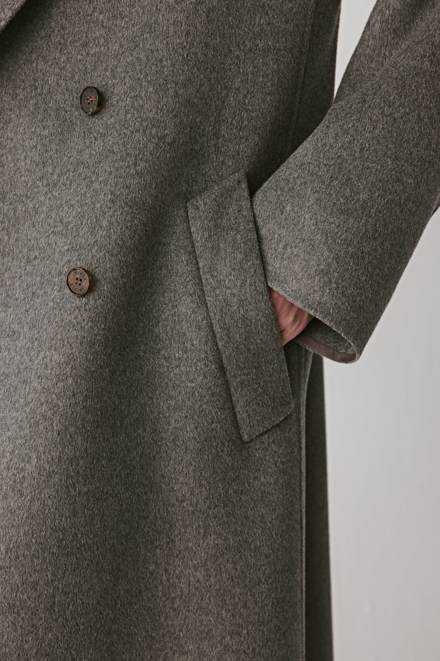 Detail shot of the collar and buttons, emphasizing craftsmanship and refined finishing.