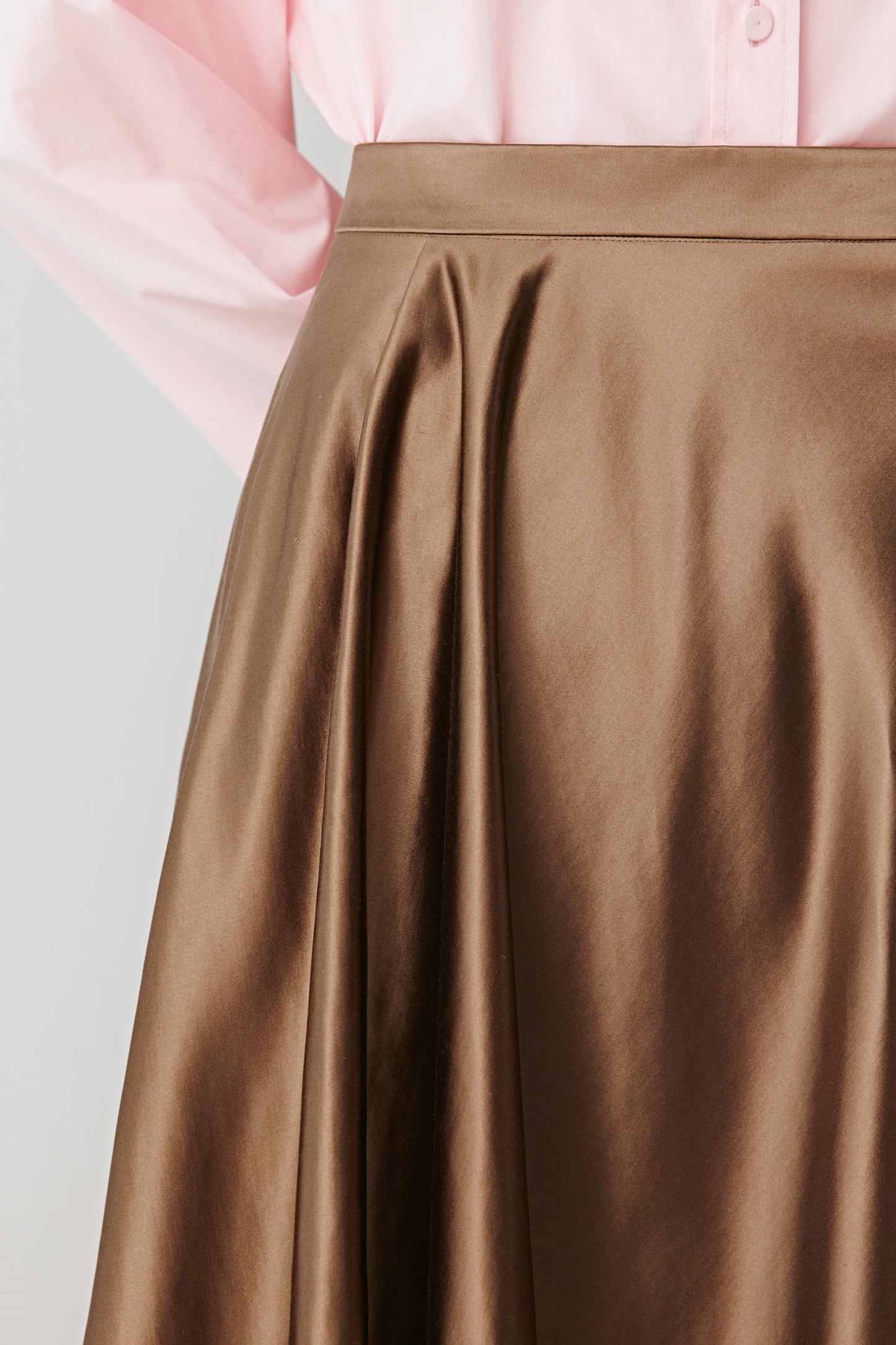 Close-up of the hem and fabric texture revealing the play of light on the satin finish.