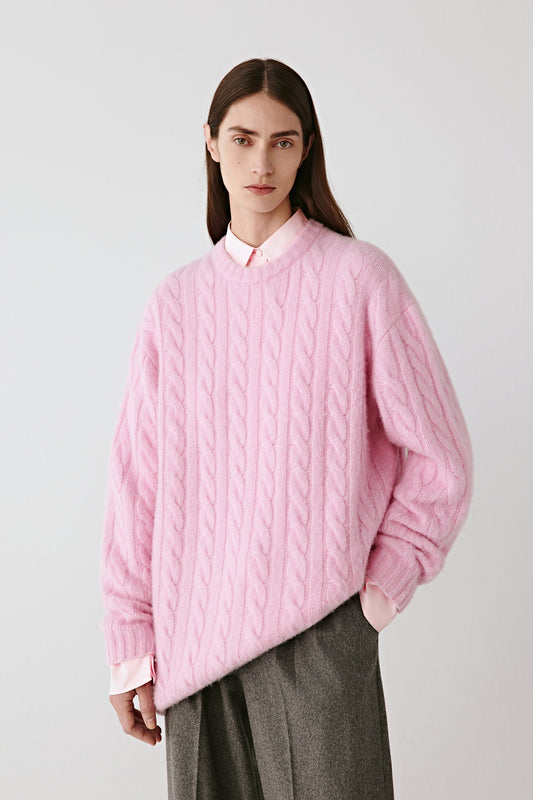 Three-quarter view of the pullover, showing its relaxed drape and refined cable pattern.