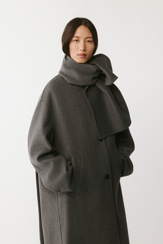 Three-quarter front view highlighting the coat's cut and relaxed sleeves.