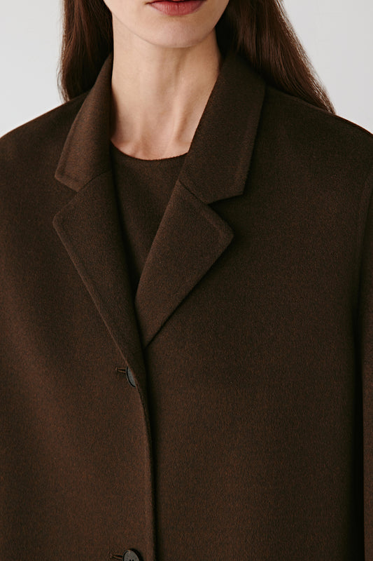 Three-quarter view highlighting the notched collar and fluid drape of the double-faced fabric.