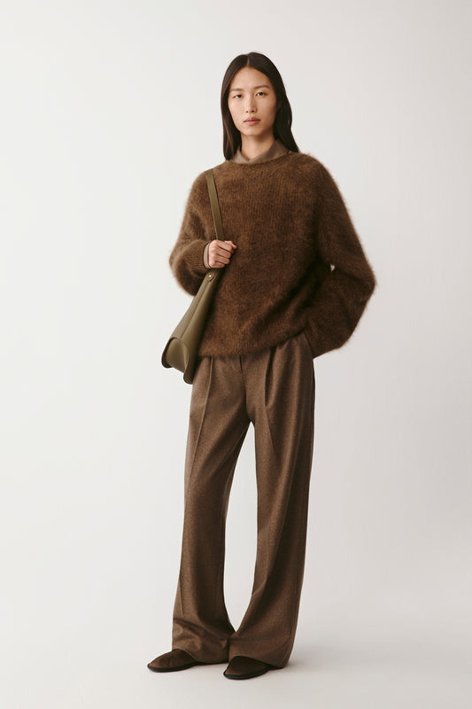 Full-length front view of the model wearing the brown cashmere cardigan with tonal trousers.