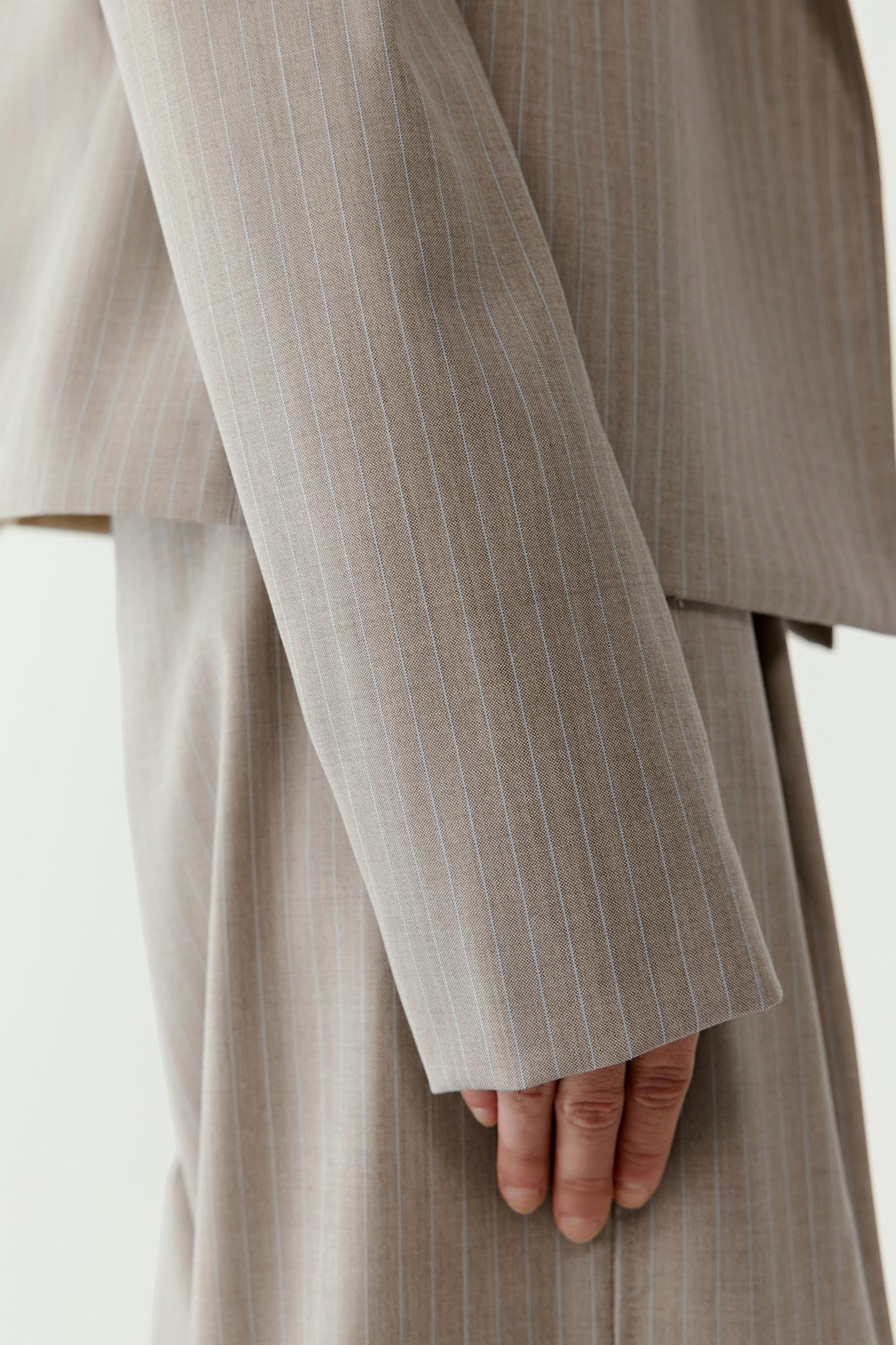 Close-up of the sleeve and cuff showing the texture of the wool, subtle pinstripes and clean finishing details