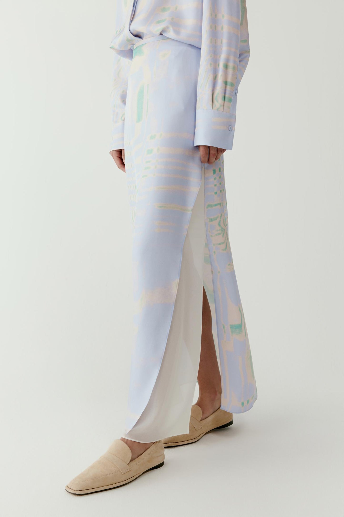 Close-up of the lower skirt and hem showing the fine silk texture, fluid structure and detailed print across the fabric