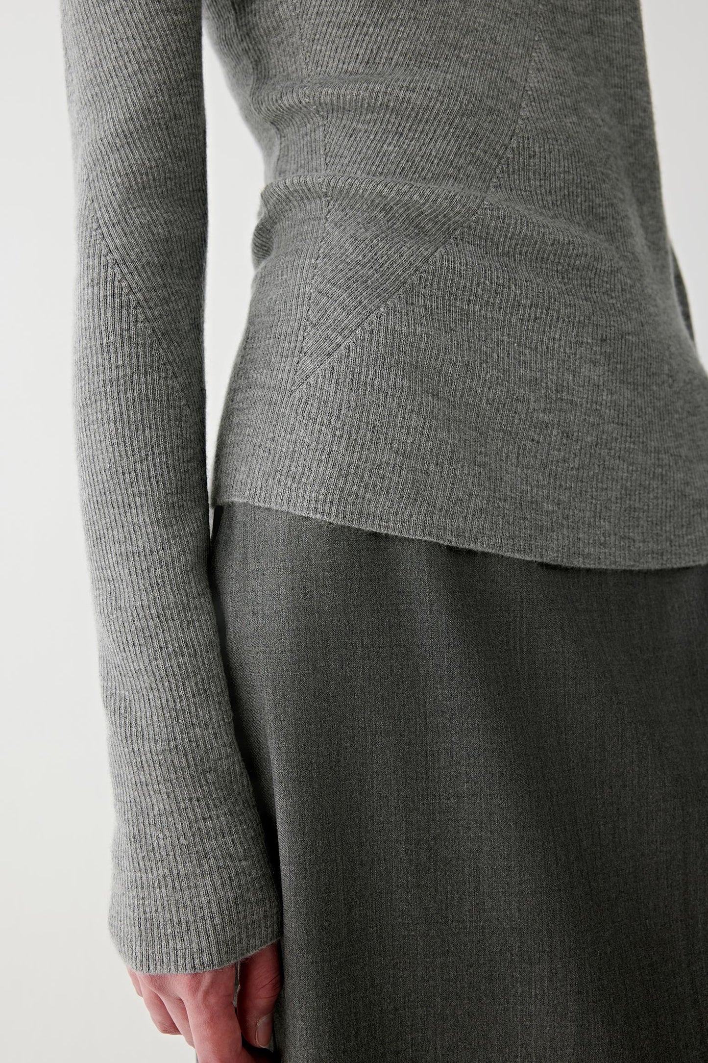 Close-up of the sleeve and cuff, showing precise ribbing and refined finishing.