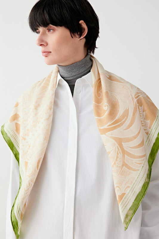 Side view of the scarf laid out, revealing the complete motif and smooth silk-cashmere texture.