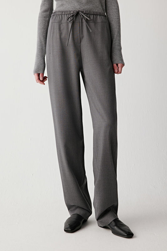 Front view highlighting the balanced straight-leg cut and the fluid drape of the wool twill fabric as it falls from the hips toward the hem.