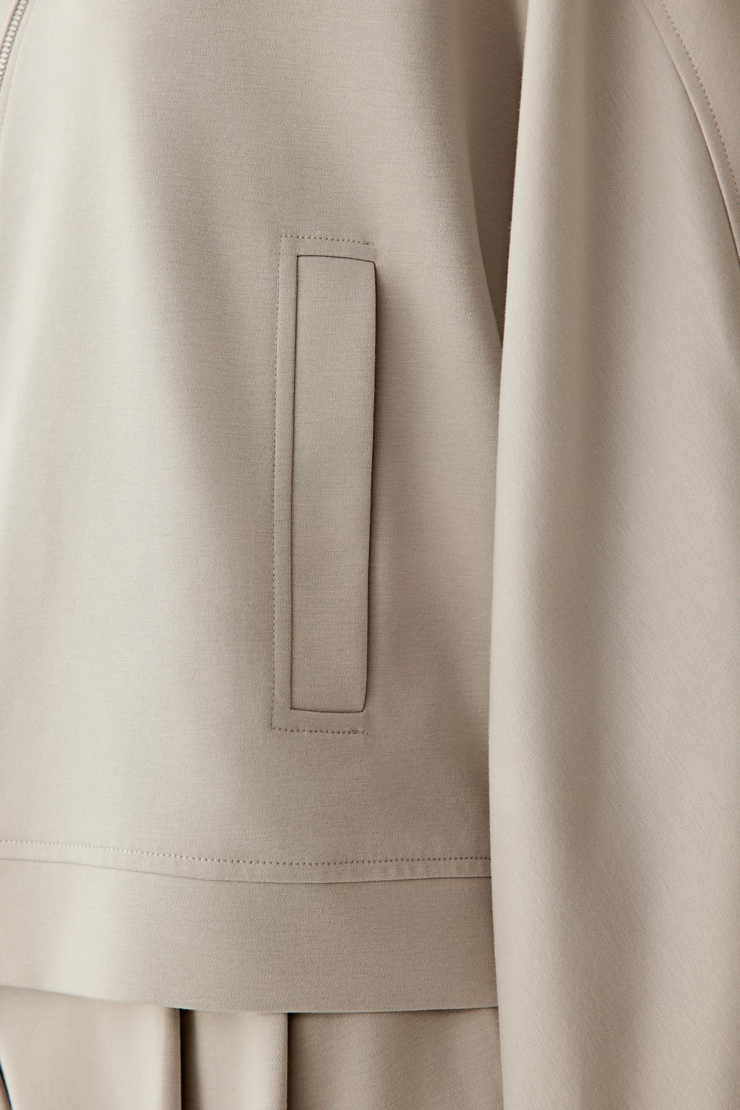 Detail close-up of the sleeve and hem, emphasizing the fabric’s softness and flexibility.