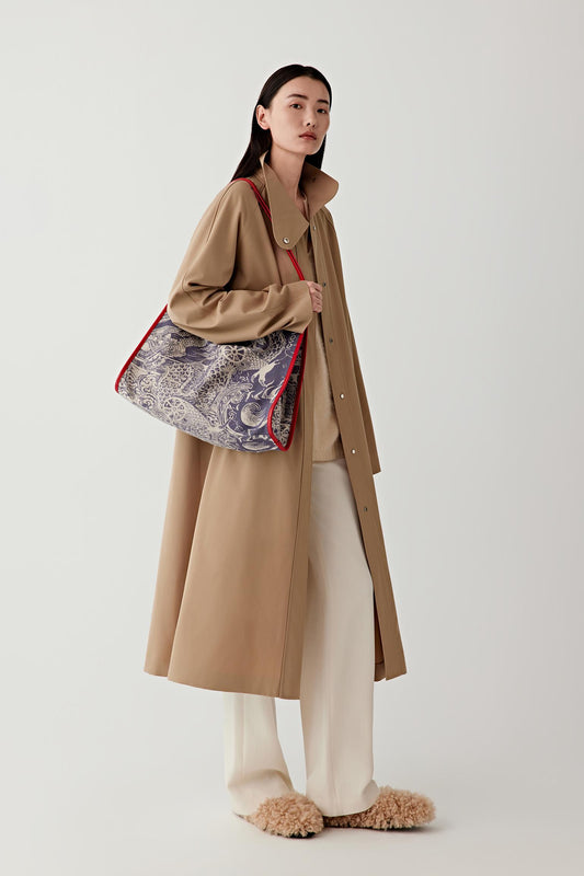 Full-length view of the linen and cotton tote bag worn with a long beige coat.