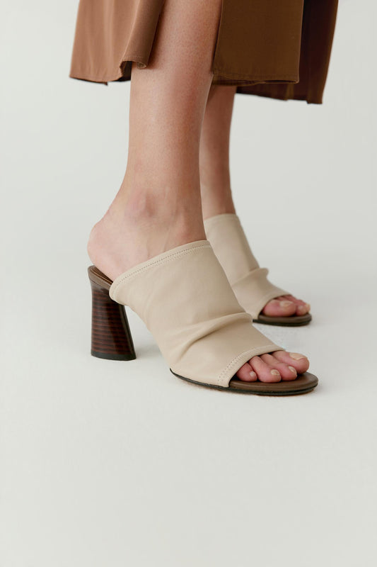 Side view highlighting the sculptural heel and the open toe construction.